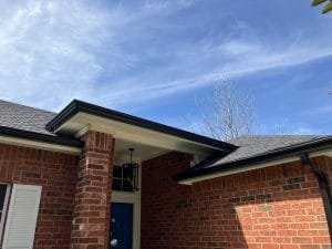 black gutters on red brick home front door entryway