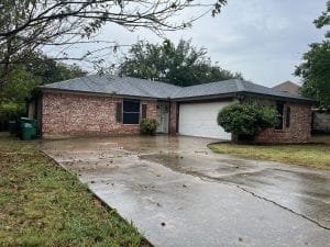 street view of red and white brick home with dark gutters
